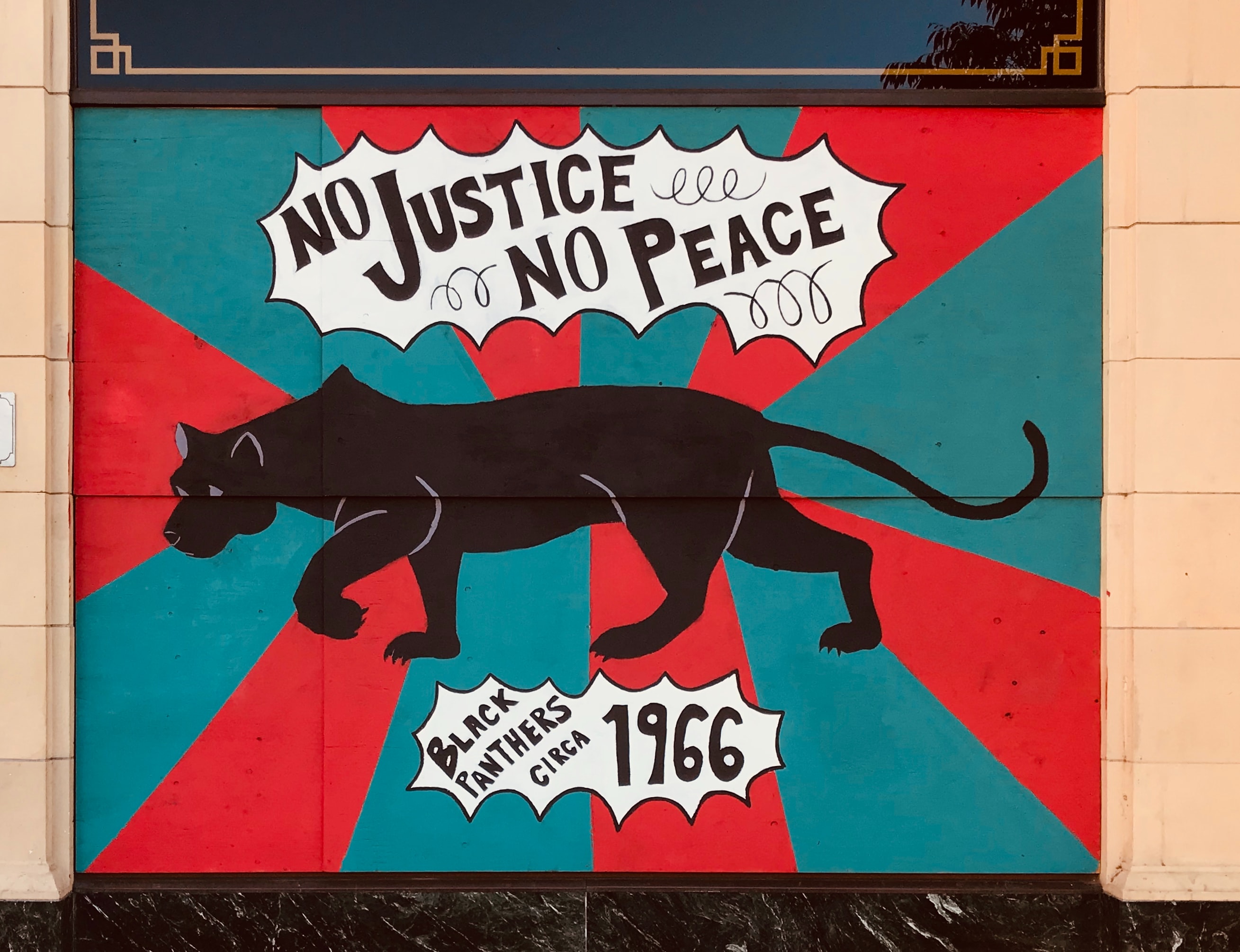 A mural that reads "No Justice No Peace" with a black panther. 