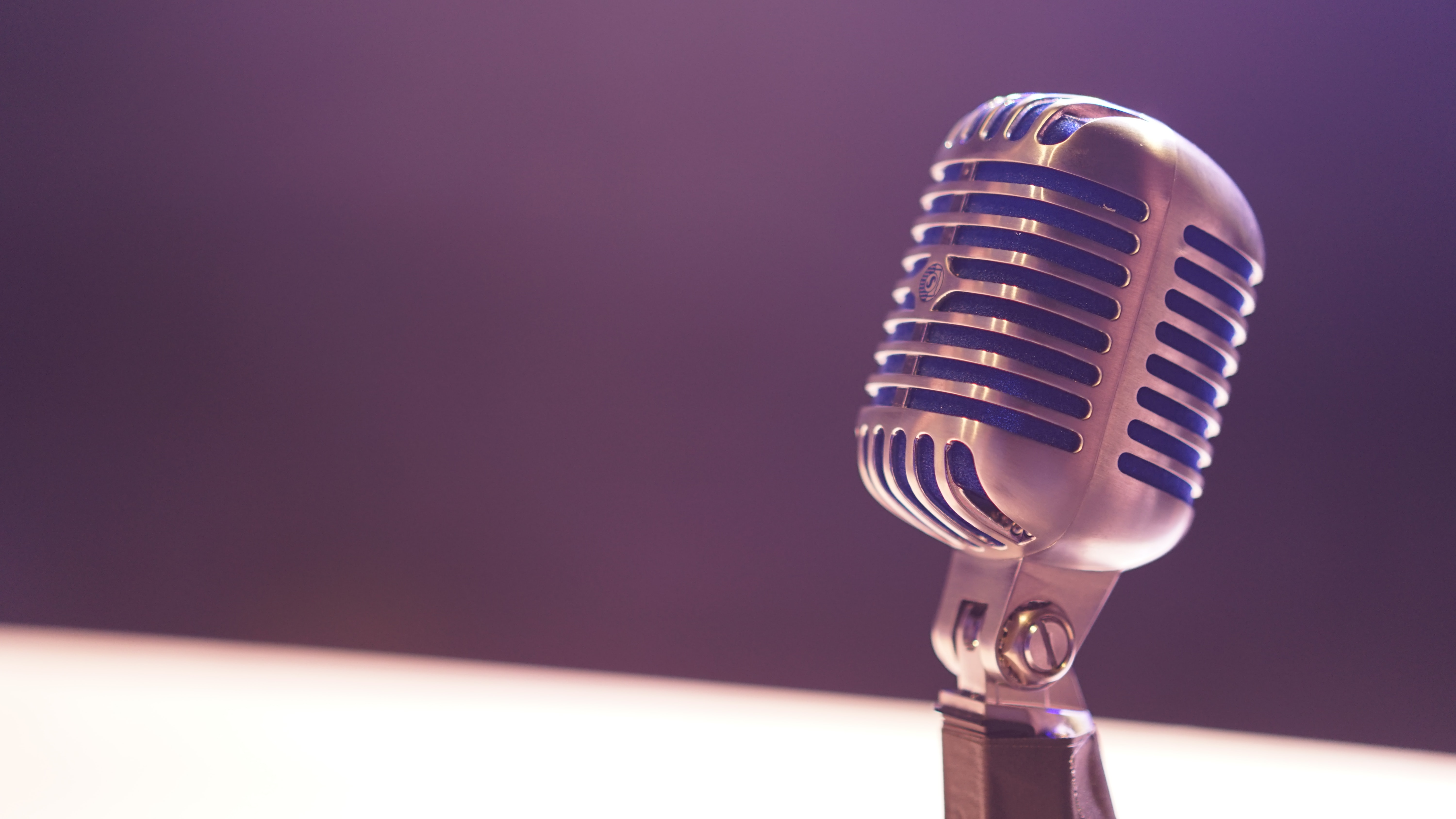 Microphone on a white table with black background.