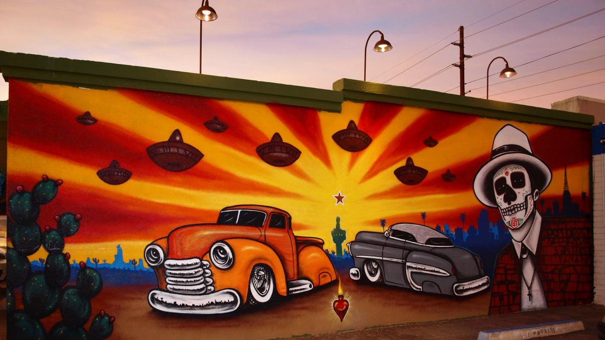 Mural of a skeleton and two cars. 