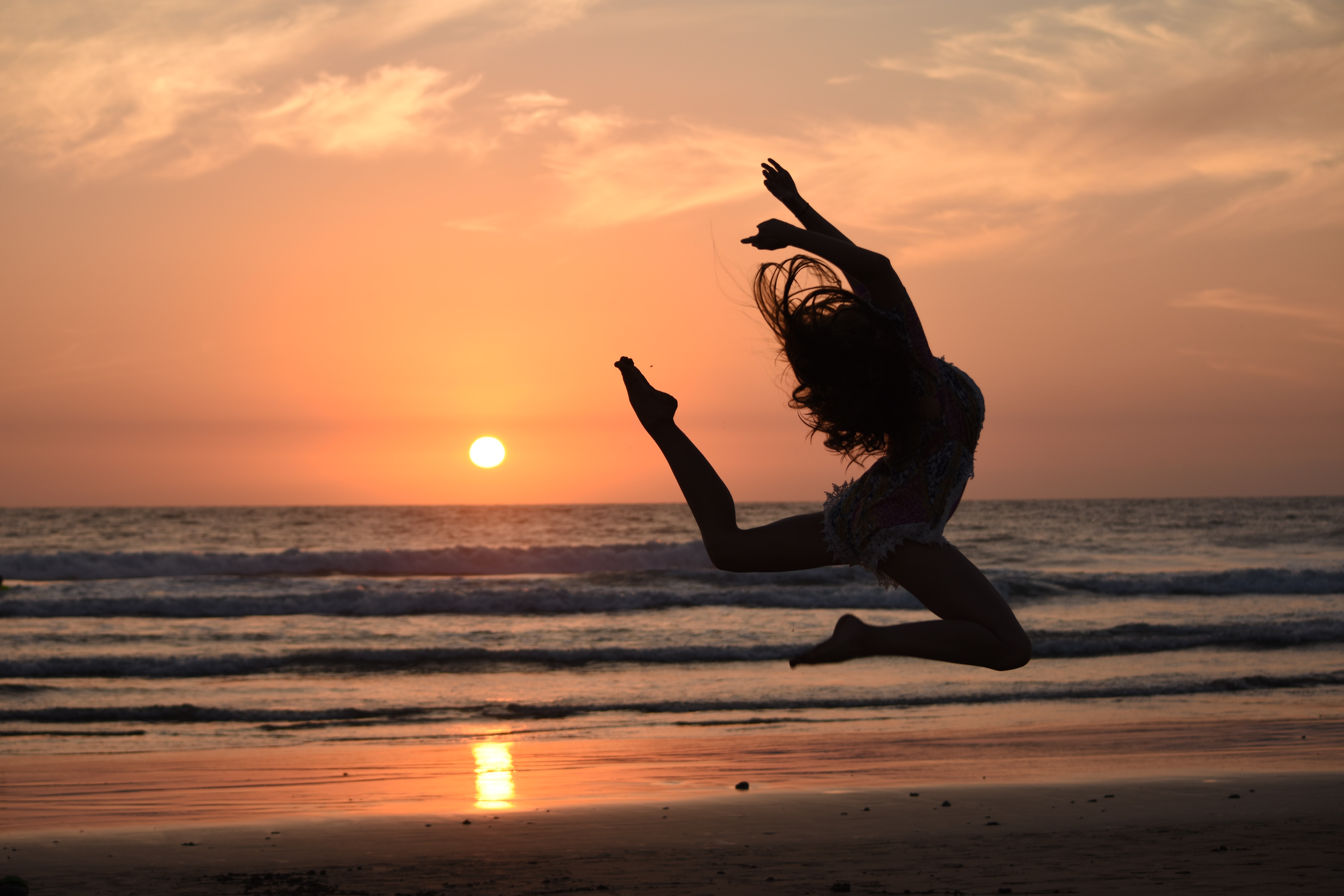 Dancer in silhouette on beach in sunset